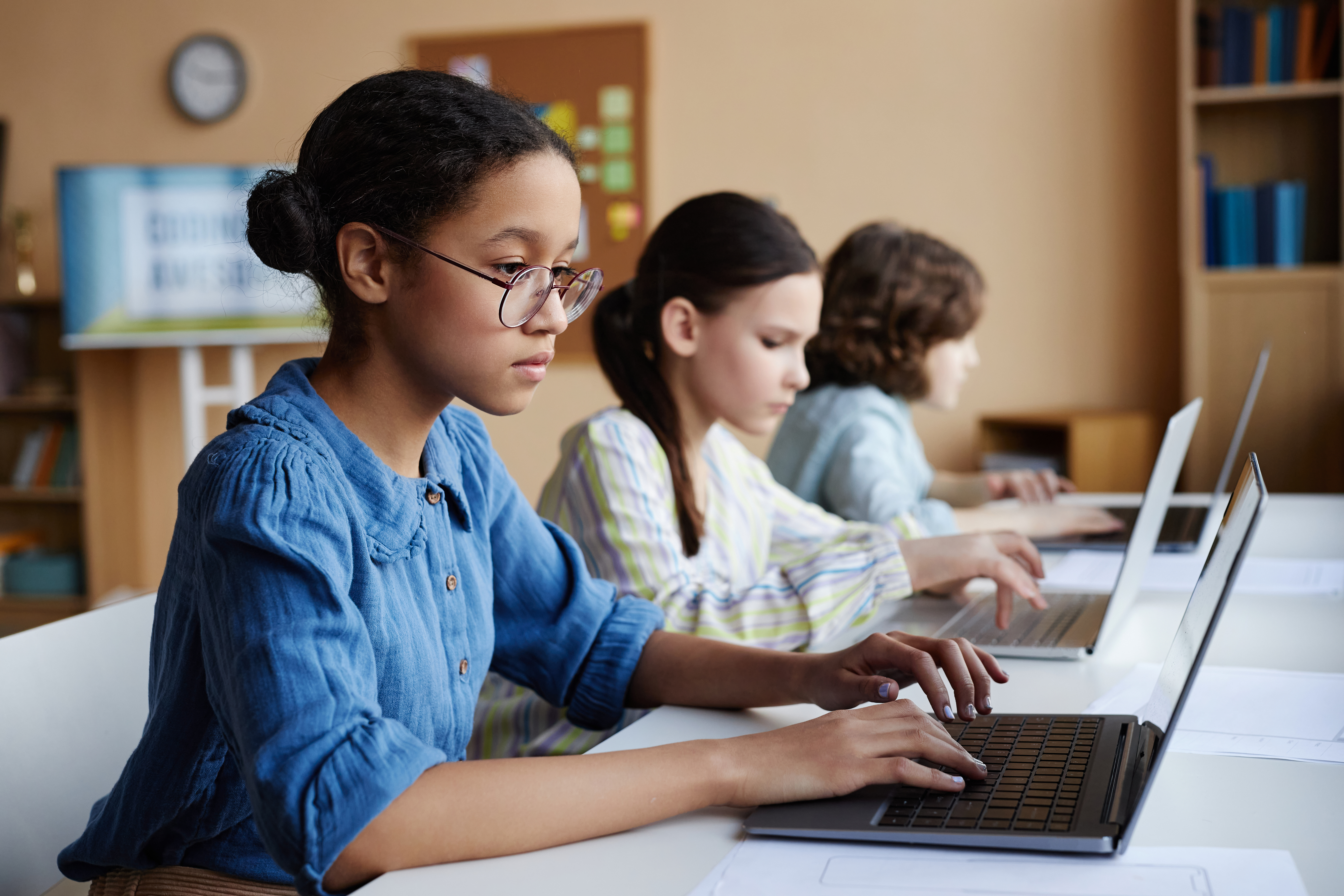 Alunos com computadores em sala de aula